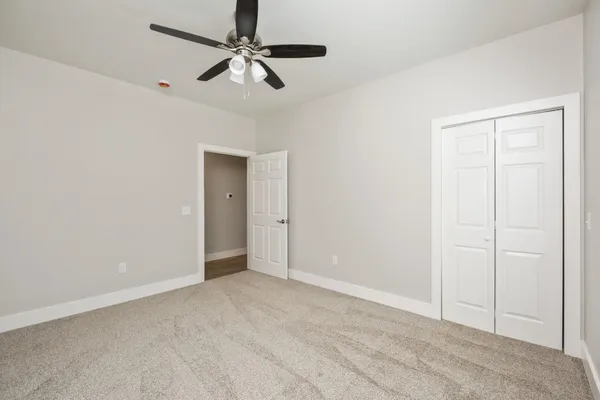 a view of an empty room with a ceiling fan