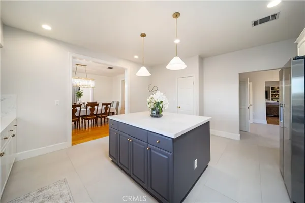 a view of a kitchen island a sink wooden floor and a living room view