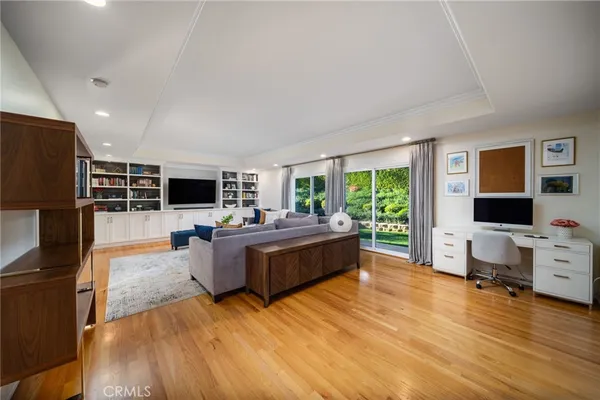a living room with furniture flat screen tv and a wooden floor