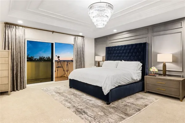 a bedroom with a bed and a chandelier