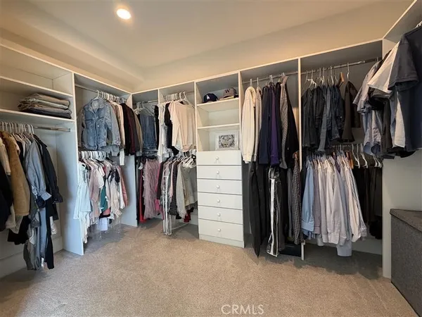 a view of walk in closet with clothes