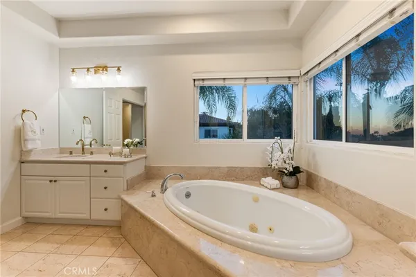 a bathroom with a tub sink and mirror