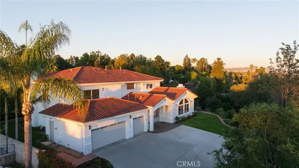 a front view of a house with a yard and palm trees