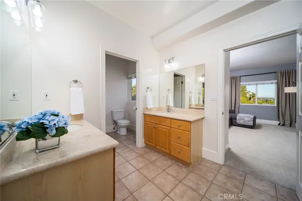 a spacious bathroom with a granite countertop sink a mirror and a bathtub