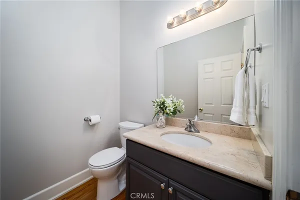 a bathroom with a granite countertop sink toilet and a mirror