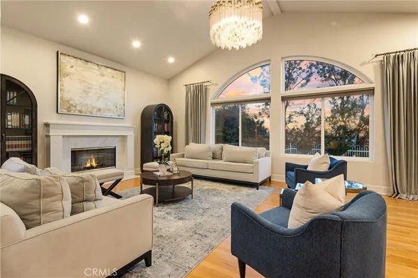 a living room with furniture a fireplace and a large window