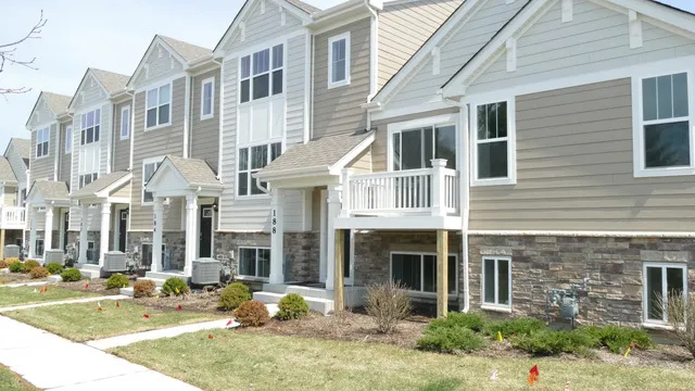 a front view of a building with garden and patio
