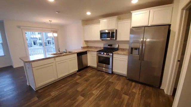 a kitchen with a sink a refrigerator a stove and cabinets