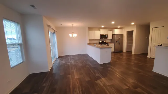 a kitchen with stainless steel appliances granite countertop a refrigerator and a stove top oven