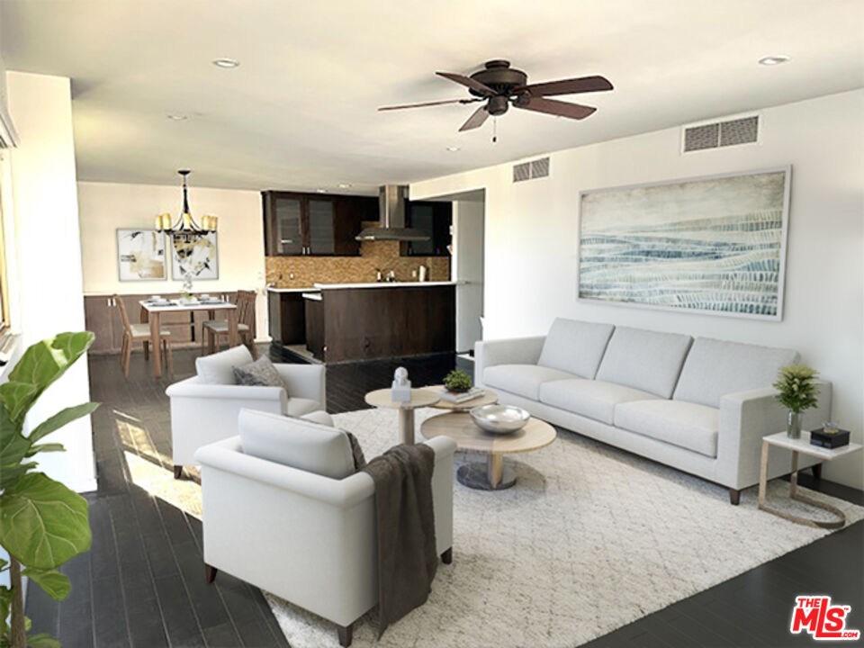 a living room with furniture kitchen view and a flat screen tv