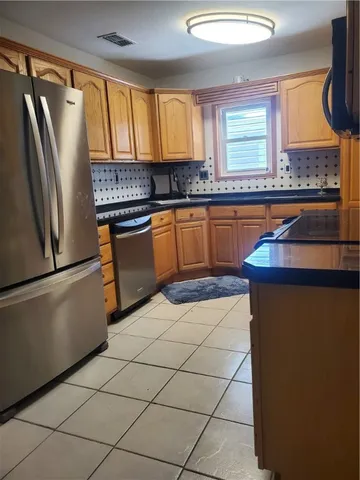 a kitchen with granite countertop a refrigerator and a sink