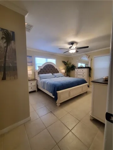 a living room with a bed furniture and a ceiling fan