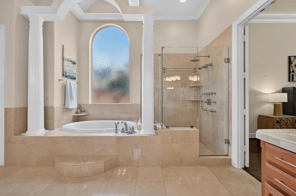 6416 Riverside Drive Plano, TX 75024 - Photo 21 of 35 Spacious bathroom featuring a built-in soaking tub with steps, a large arched window with privacy glass, and a glass-enclosed shower with multiple showerheads