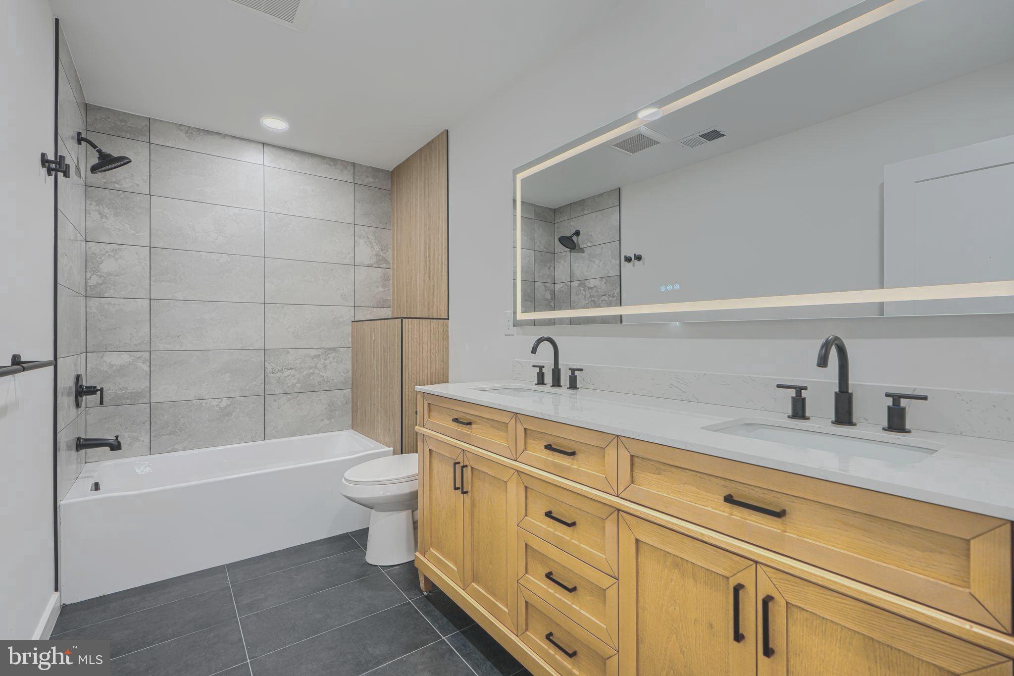 3410 Pinkney Road Baltimore, MD 21215 - Photo 20 of 55 a bathroom with a granite countertop sink a toilet and bathtub