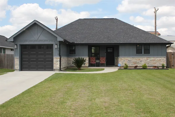 a front view of house with yard outdoor seating and garage
