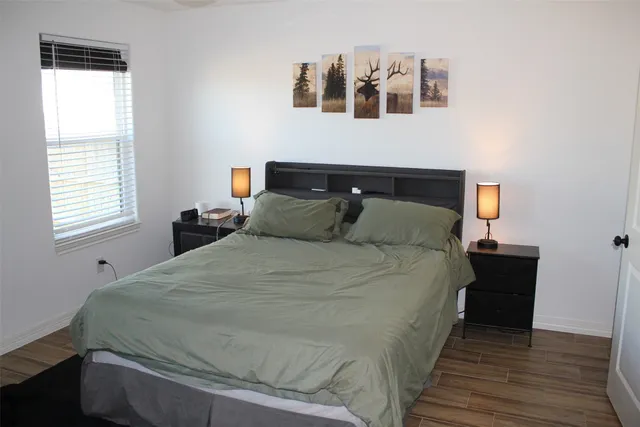 a bedroom with a bed and wooden floor