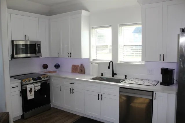 a kitchen with stainless steel appliances granite countertop a sink stove and microwave