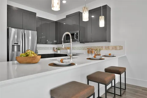 a kitchen with a sink and chairs