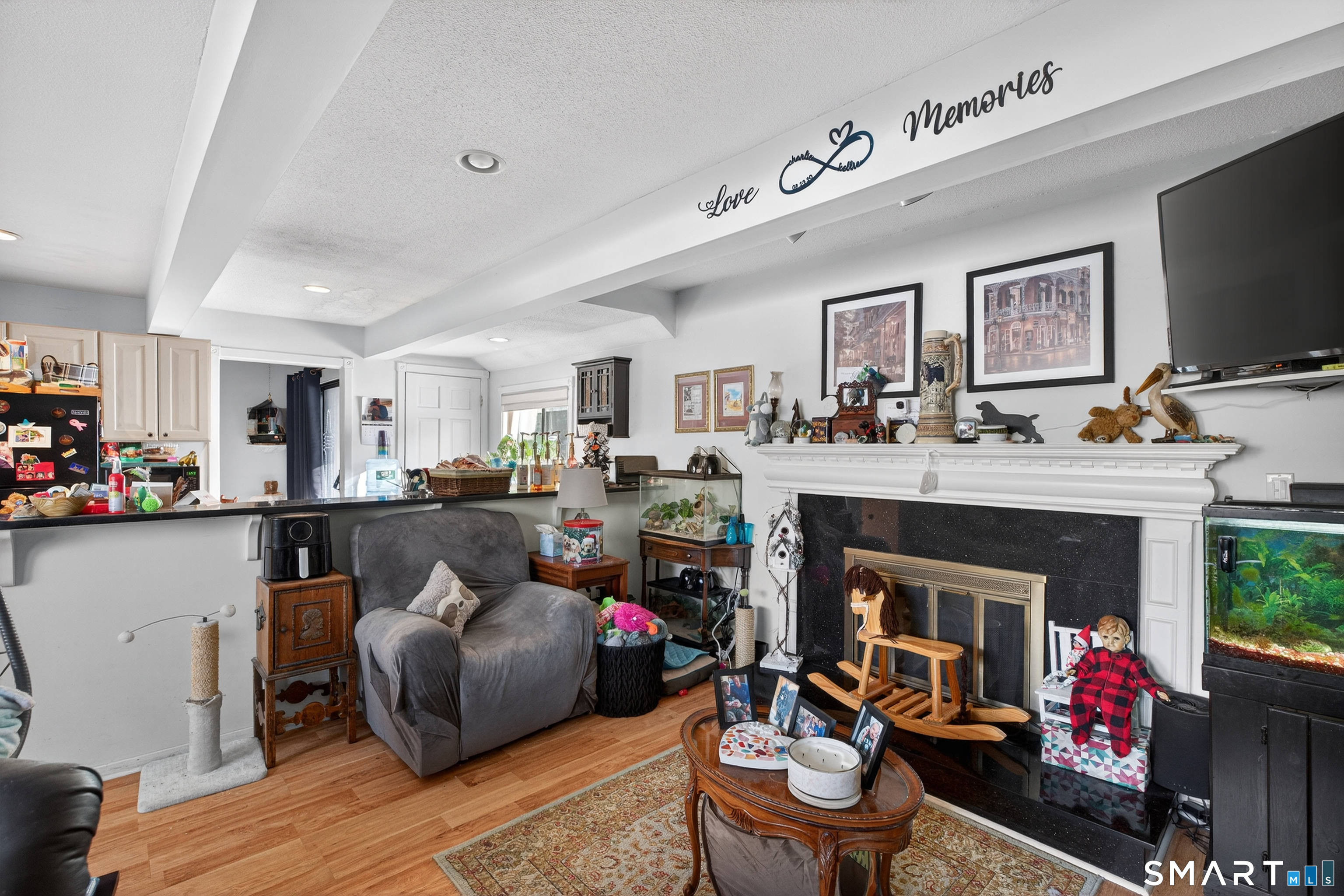 9 Upper Commons, Unit 9 Woodbury, CT 06798 - Photo 10 of 38 a living room with furniture a flat screen tv and a fireplace