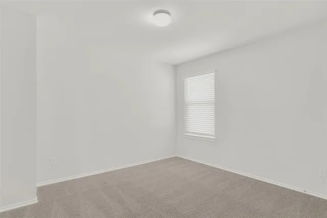 an empty room with a window and a ceiling fan