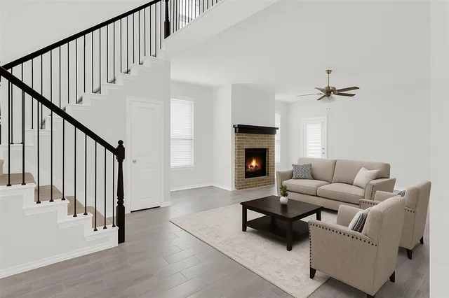 a view of an empty room with wooden floor fireplace and a window