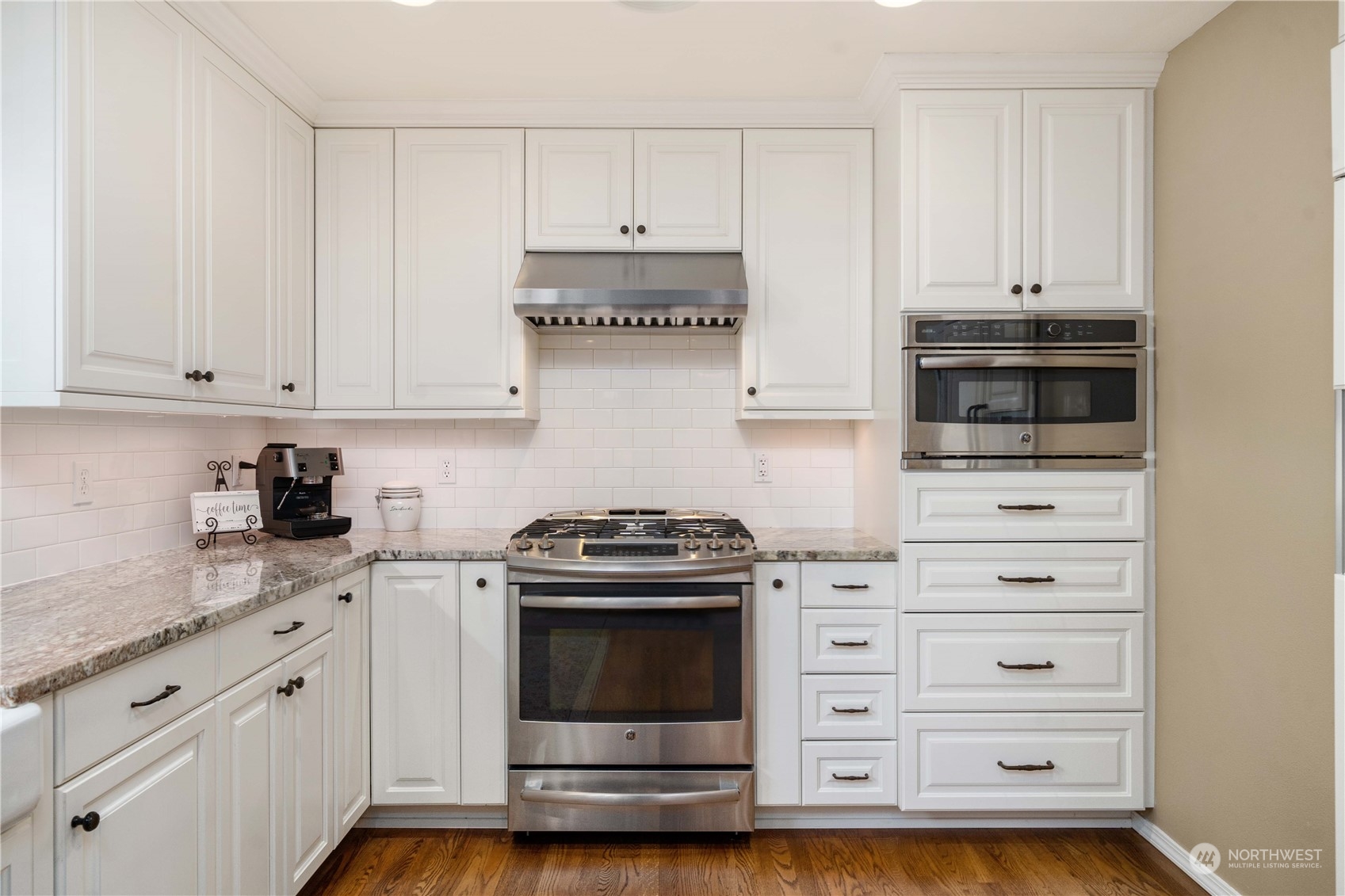 17811 87th Avenue East Puyallup, WA 98375 - Photo 12 of 37 a kitchen with granite countertop white cabinets and stainless steel appliances