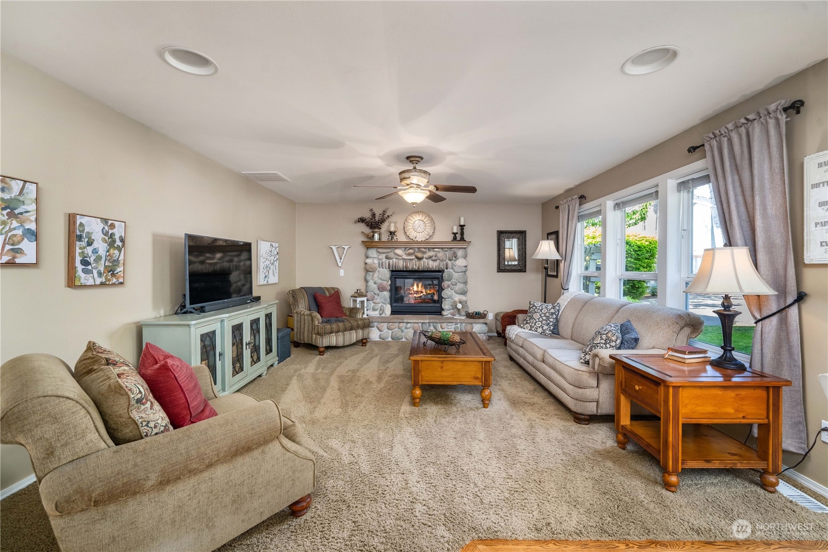17811 87th Avenue East Puyallup, WA 98375 - Photo 14 of 37 a living room with furniture a flat screen tv and a fireplace