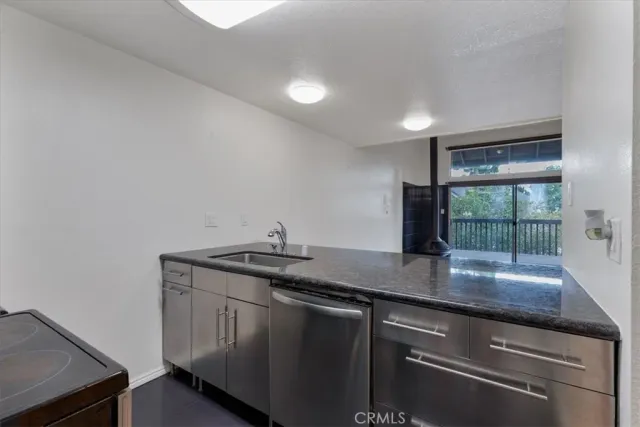 a kitchen with stainless steel appliances granite countertop a sink and a hard wood floor