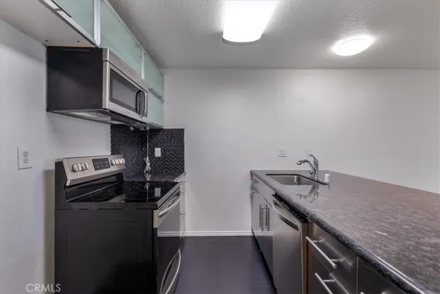a kitchen with stainless steel appliances granite countertop a sink stove and microwave