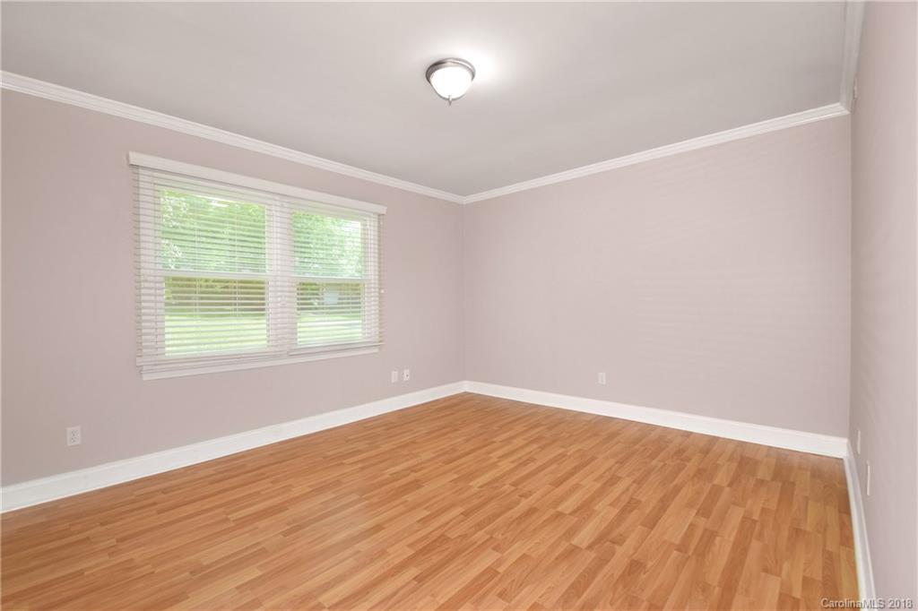 6426 Round Hill Road Charlotte, NC 28211 - Photo 4 of 23 an empty room with wooden floor and windows