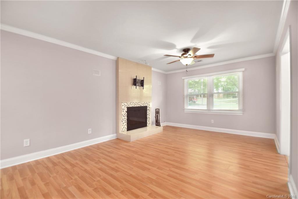 6426 Round Hill Road Charlotte, NC 28211 - Photo 7 of 23 an empty room with chandelier fan and windows