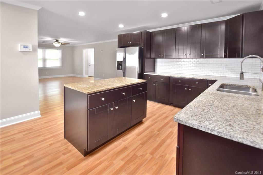 6426 Round Hill Road Charlotte, NC 28211 - Photo 8 of 23 a kitchen with kitchen island granite countertop wooden cabinets and a sink