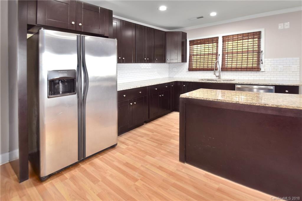 6426 Round Hill Road Charlotte, NC 28211 - Photo 10 of 23 a kitchen with stainless steel appliances granite countertop a sink a refrigerator and wooden floor