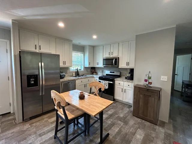 a kitchen with a refrigerator a counter top space and stainless steel appliances