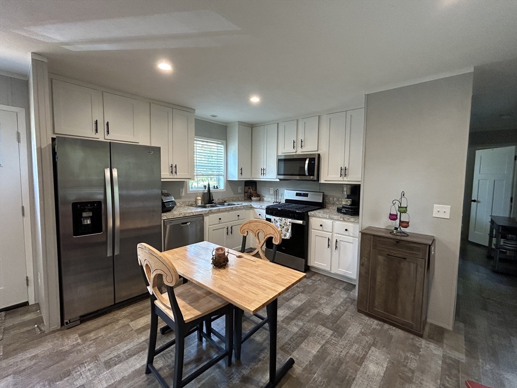 a kitchen with a refrigerator a counter top space and stainless steel appliances