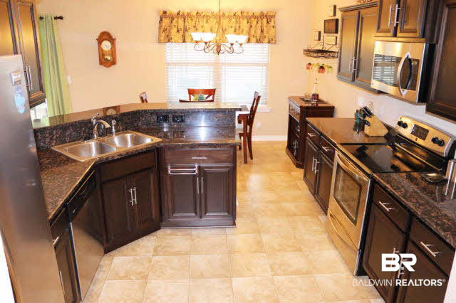 138 Meadow Run Loop West Foley, AL 36535 - Photo 7 of 24 Large kitchen has dark wood cabinets, stainless appliances, granite countertops