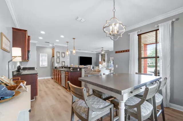 a view of a dining room with furniture a chandelier and wooden floor