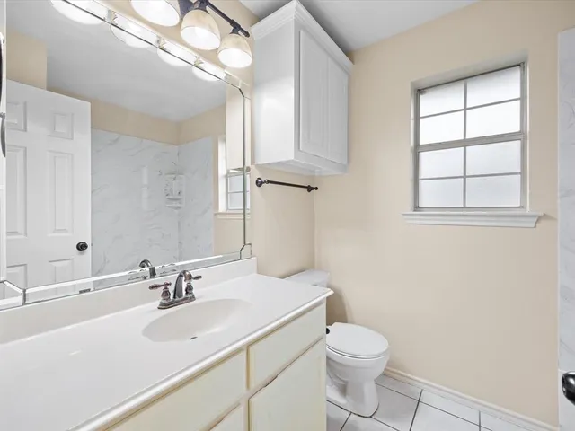 a bathroom with a sink a toilet and a mirror