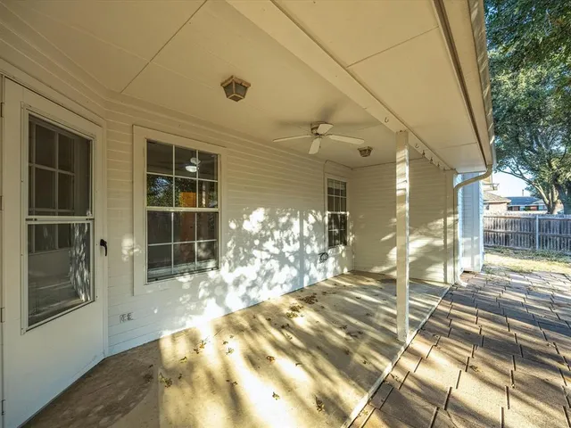 a view of a porch with a table and chairs and potted plants