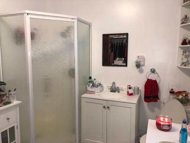 a bathroom with a sink vanity and a shower
