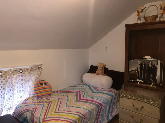 a bedroom with bed and a car