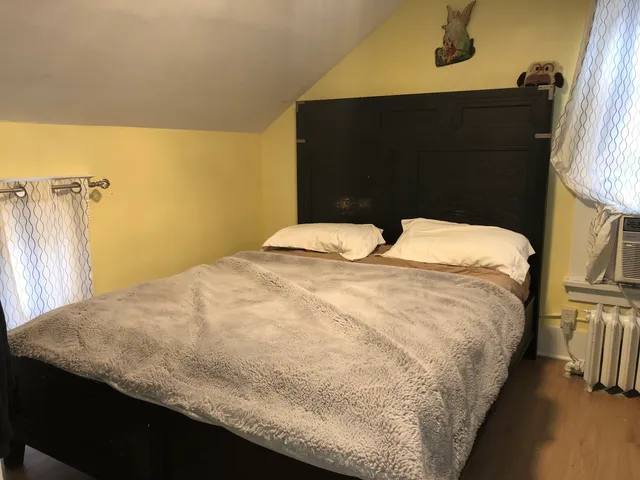 a bed sitting in a bedroom next to a window