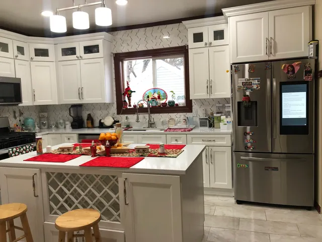 a kitchen with granite countertop stainless steel appliances a sink and a refrigerator