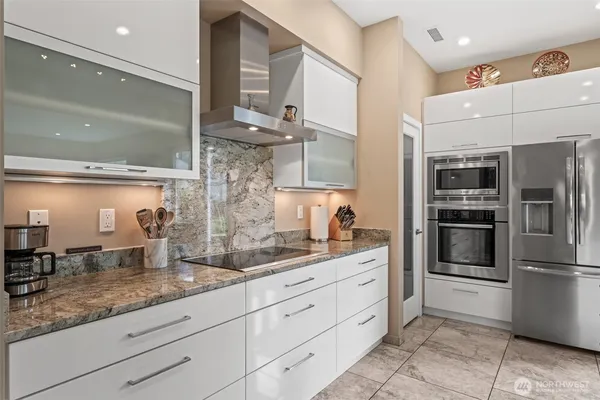 a kitchen with stainless steel appliances kitchen island granite countertop a refrigerator and a sink