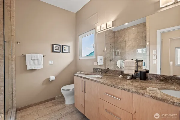 a bathroom with a granite countertop sink a toilet and a mirror