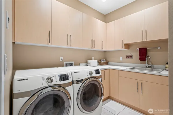 a utility room with sink dryer and washer