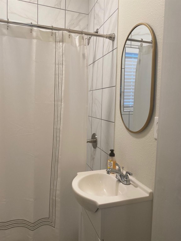 2708 Winbern Street Houston, TX 77004 - Photo 13 of 17 a bathroom with a sink a mirror and a shower