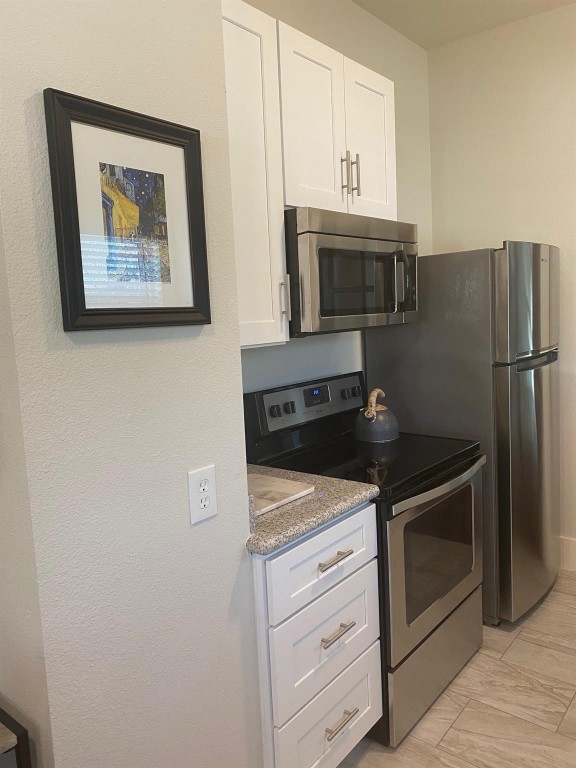 2708 Winbern Street Houston, TX 77004 - Photo 4 of 17 a kitchen with granite countertop white cabinets and stainless steel appliances