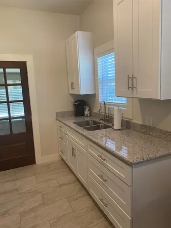 a kitchen with granite countertop a sink a stove and cabinets