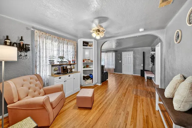 a view of a kitchen with refrigerator and wooden floor